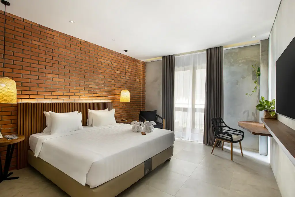 Modernas habitaciones de hotel con camas tamaño king, paredes de ladrillo y elementos de diseño ecológicos.