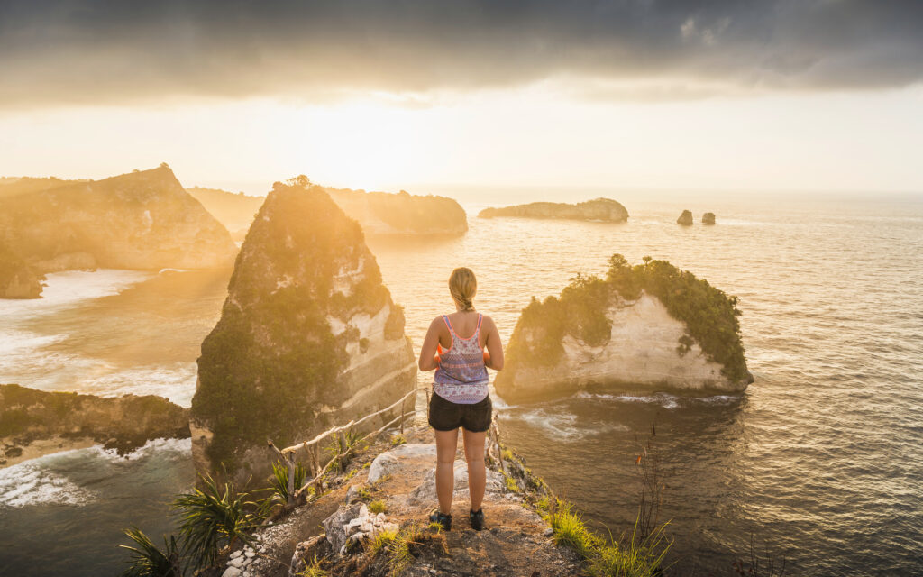 Unas mujeres admiran el amanecer en la playa de Kelingking, un espectacular acantilado con forma de T-Rex en Nusa Penida.