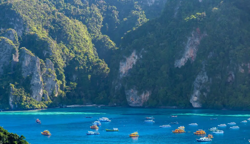 Boten in het blauwe water van Raja Ampat omringd door weelderige groene kliffen