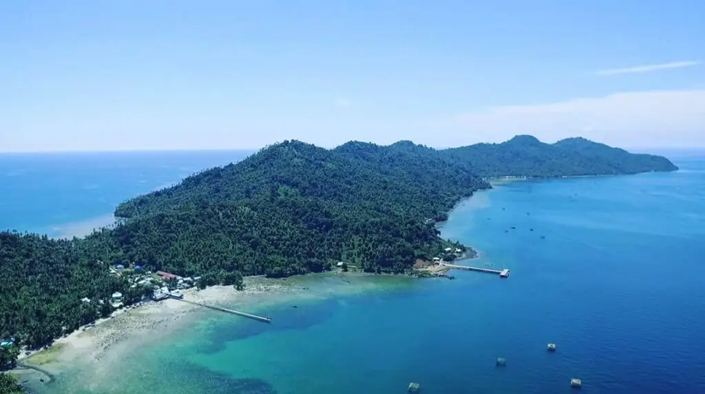 Een luchtfoto van Lemukutan Island, West-Kalimantan, met zijn weelderige groene heuvels en helderblauwe water; een verborgen paradijs om te duiken en snorkelen.