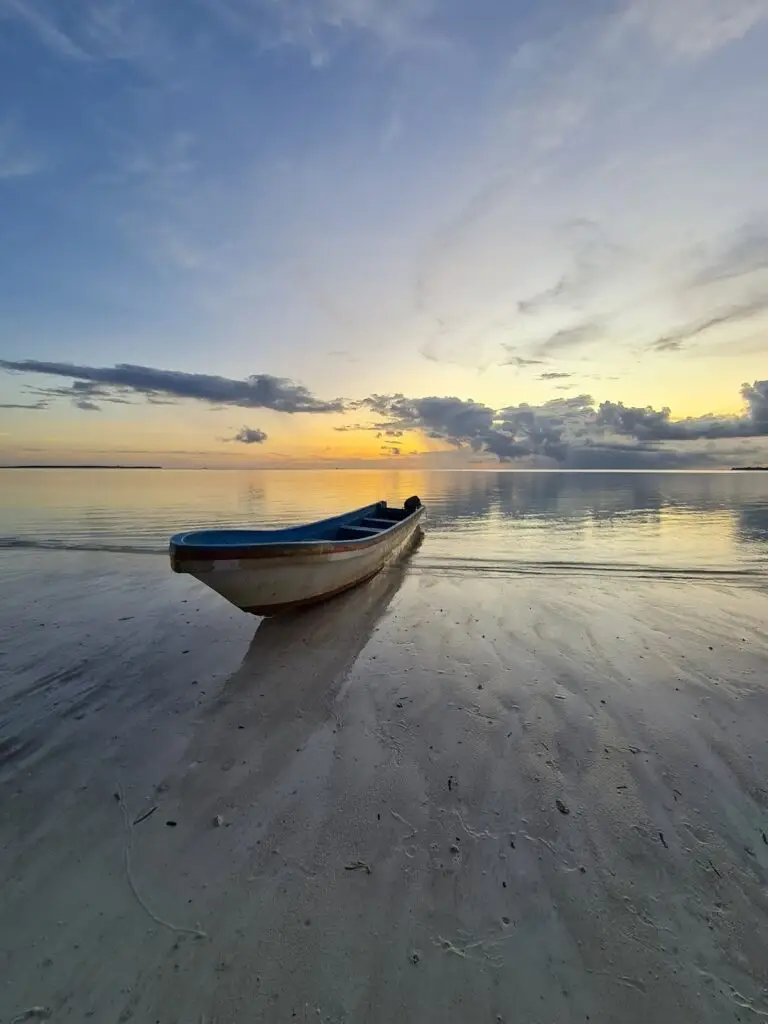 Boats at Ngurbloat Beach at sunset, a must-visit destination.