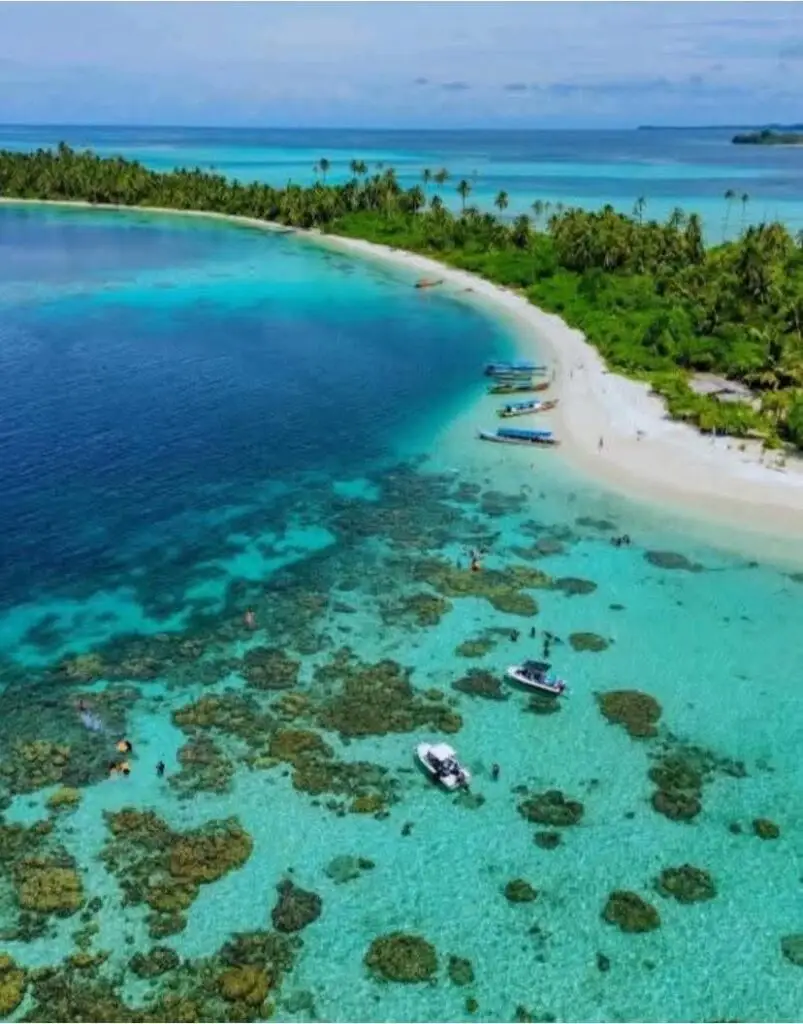 The turquoise waters of Pulau Banyak Aceh Singkil, a hidden paradise with boats and coral reefs.