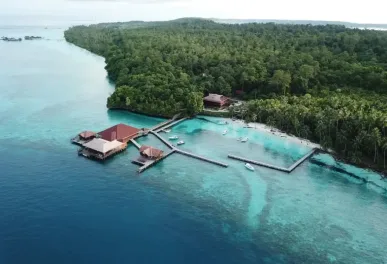 Prachtige stranden met resorts en aanlegsteigers op een tropisch eiland omringd door groene bossen en heldere zee in Indonesië - Tour Maratua